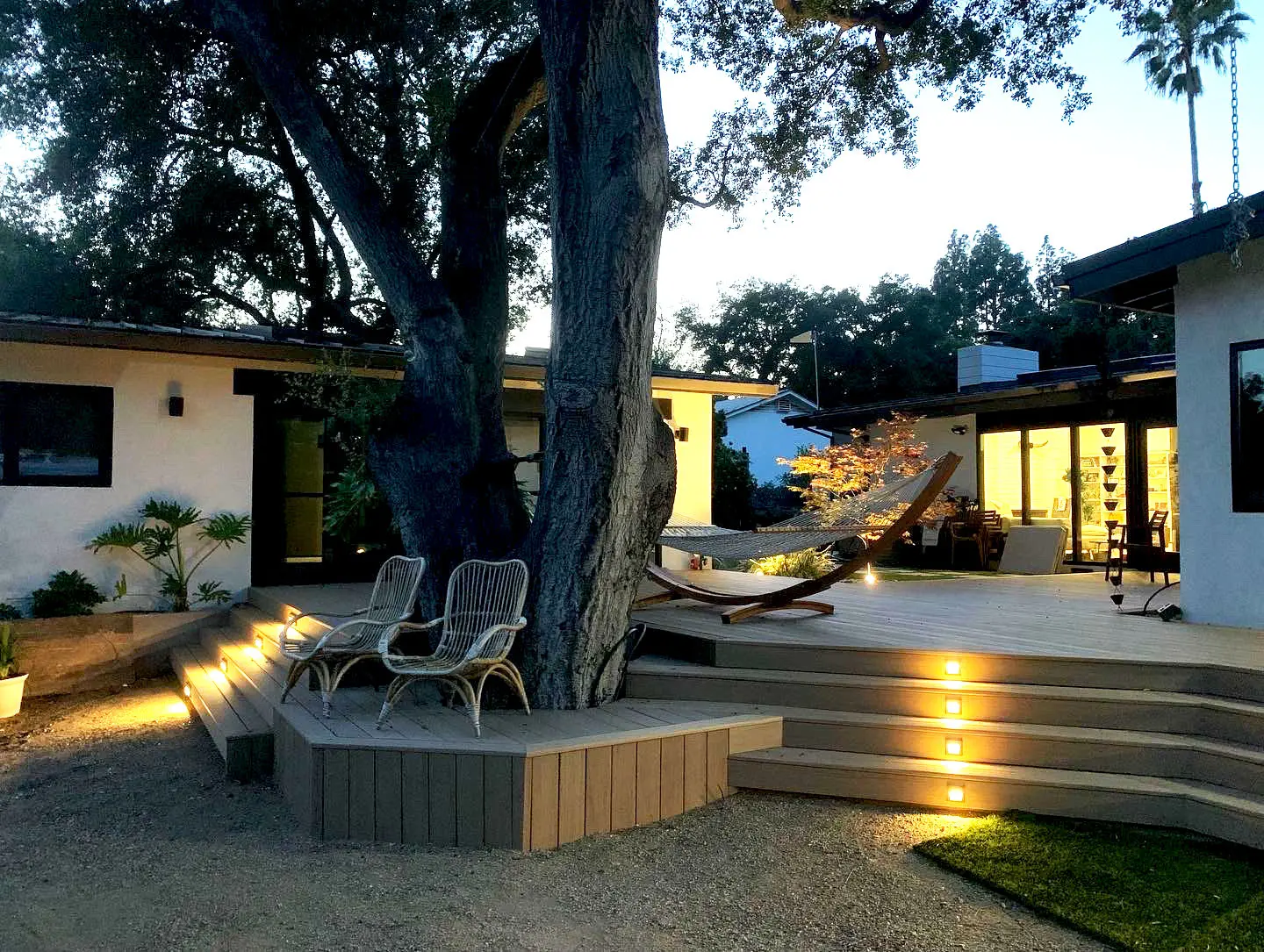 Deck built around a mature tree, with lit steps