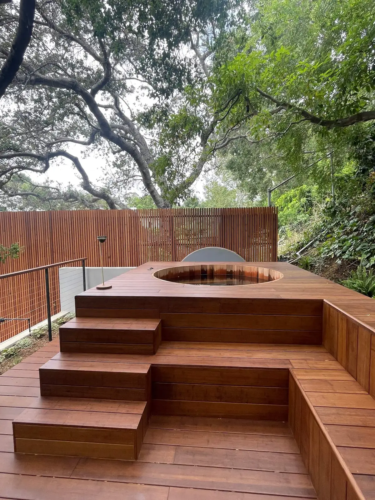 Raised deck with a built-in hot tub and steps
