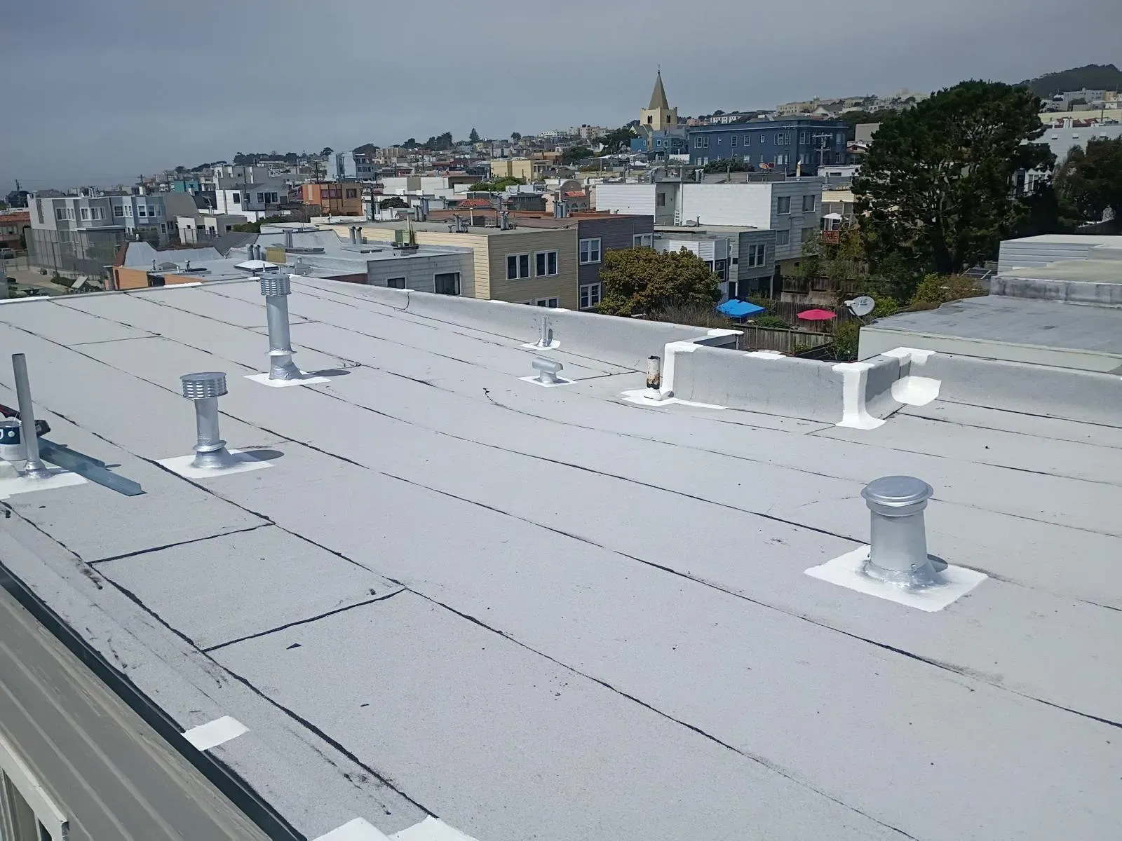 Flat roof with sealed vent flashings
