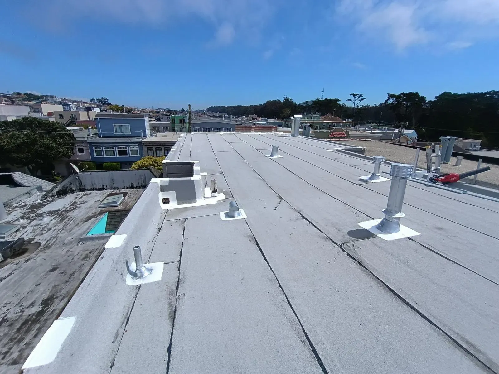 Flat roof with new vent pipes and parapet flashing