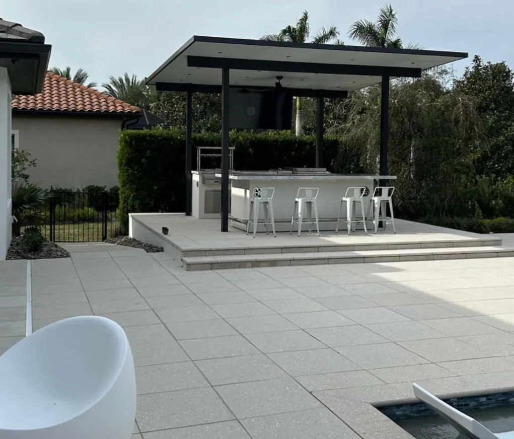 Covered outdoor kitchen bar on a raised paver platform