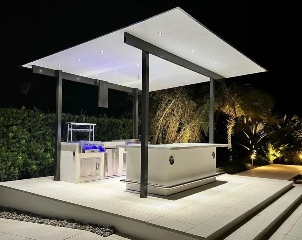 Outdoor kitchen under a flat-roof pavilion with recessed lights