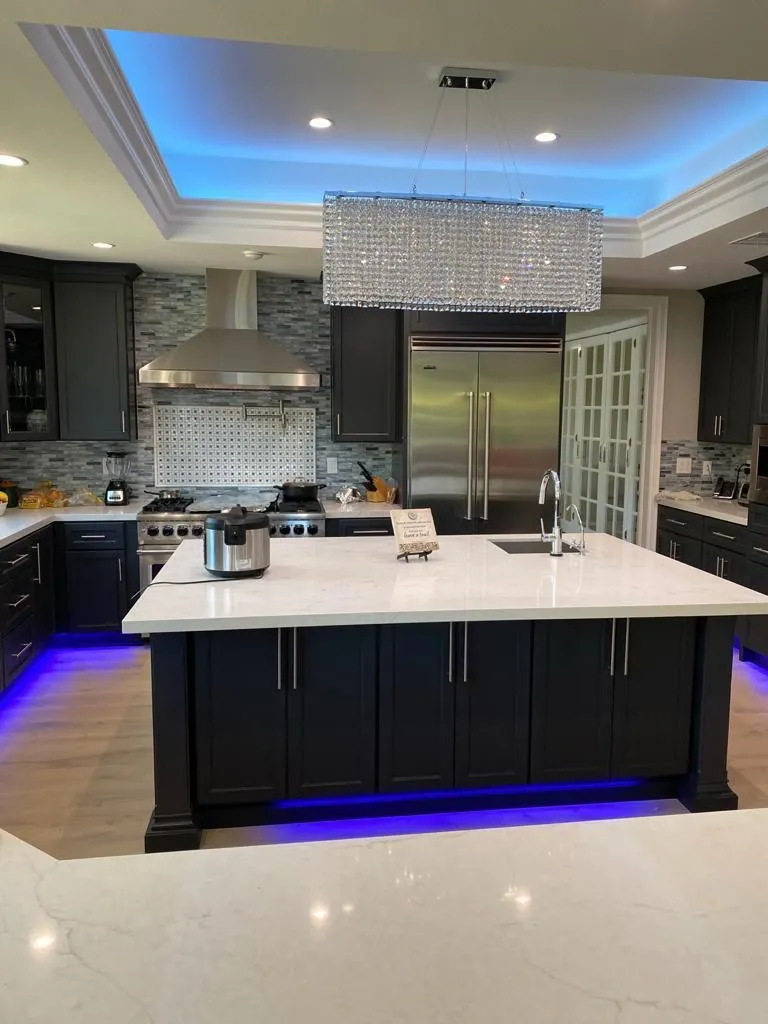 Kitchen with dark shaker island and white stone countertop