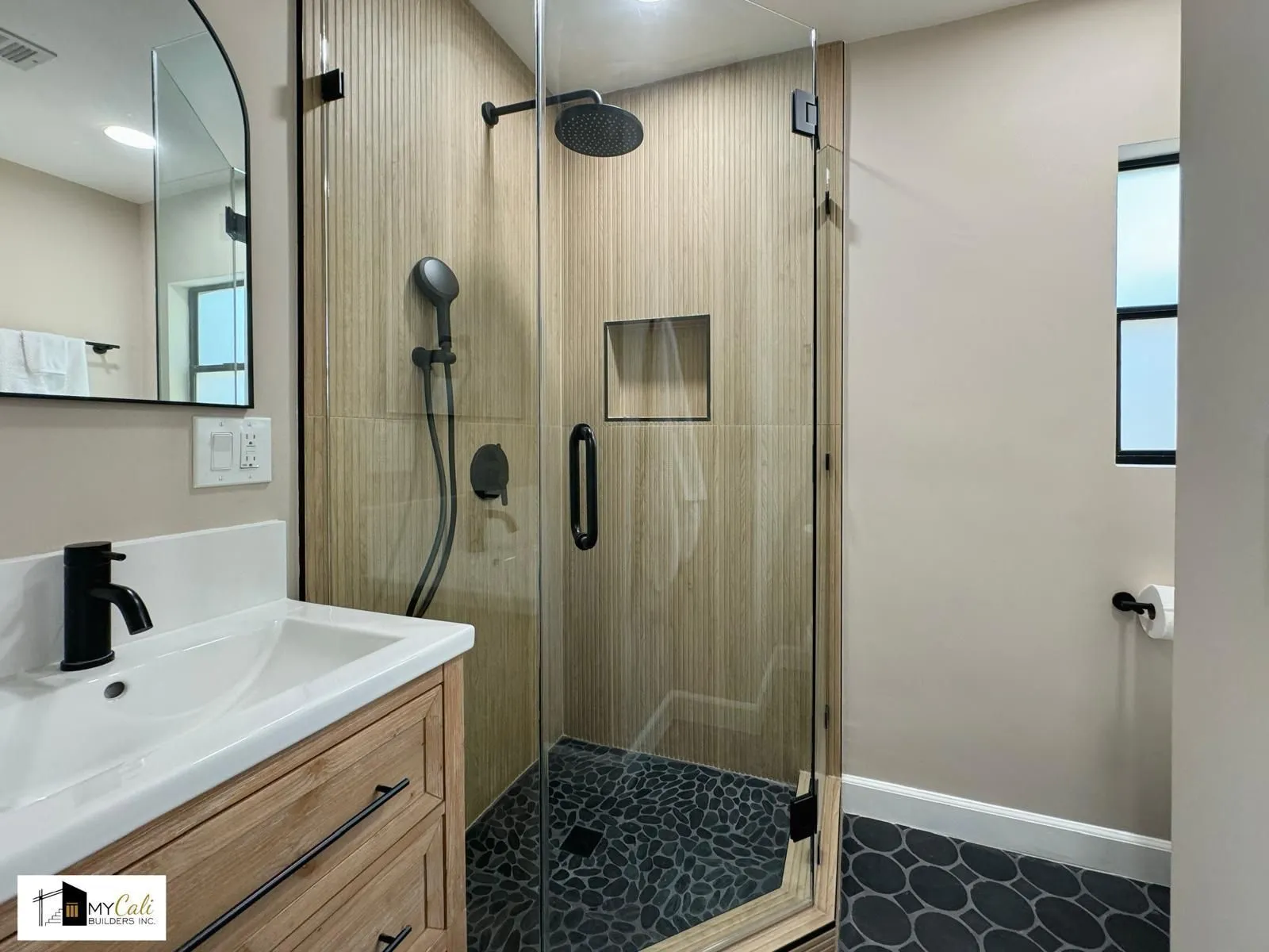 Walk-in shower with wood-look tile and pebble floor