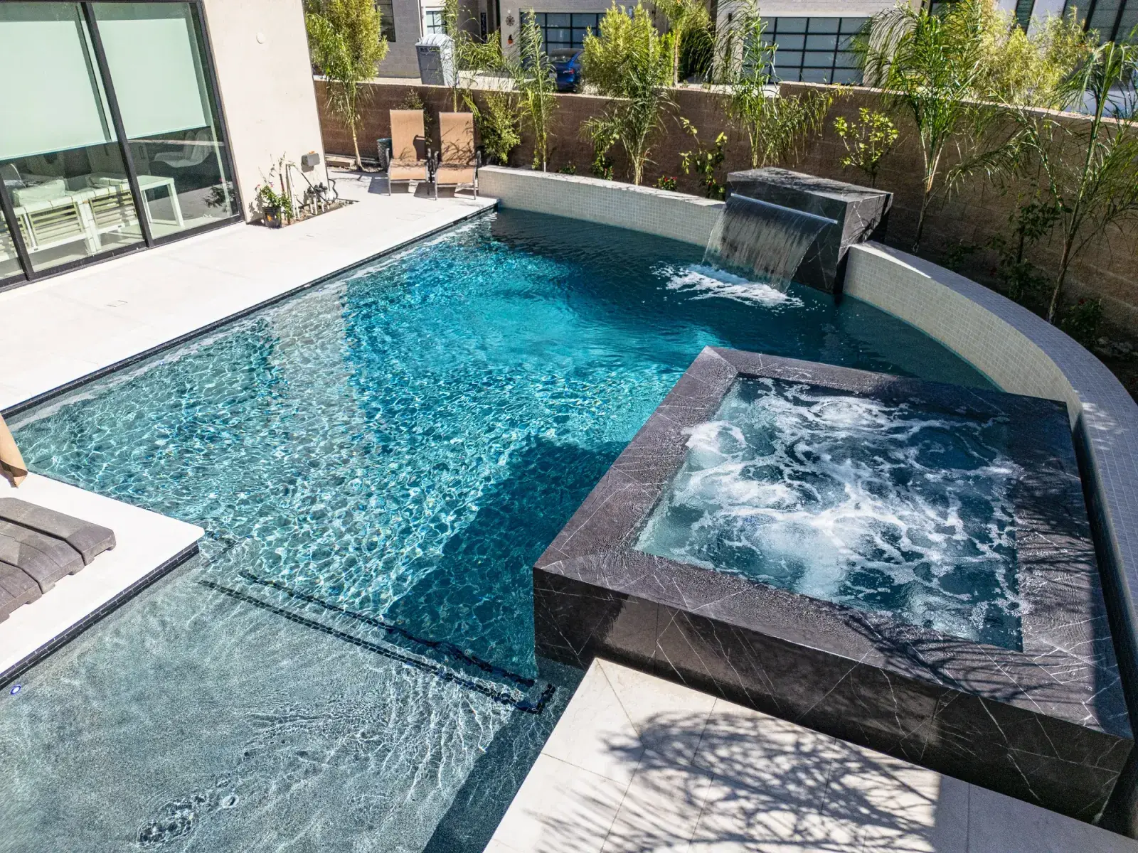 Compact pool with dark raised spa and scupper wall, Porter Ranch