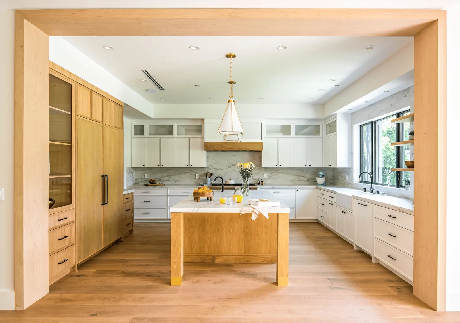 Kitchen with painted cabinets and a white oak island and pantry wall