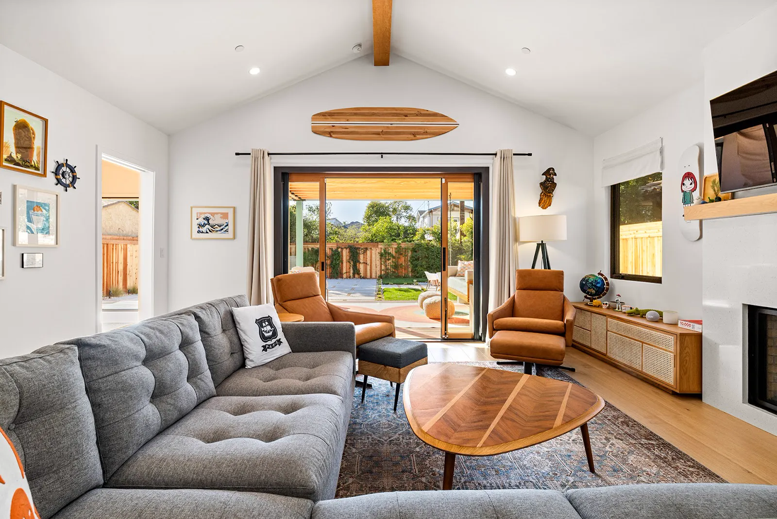 Living room with vaulted beamed ceiling opening to the covered deck
